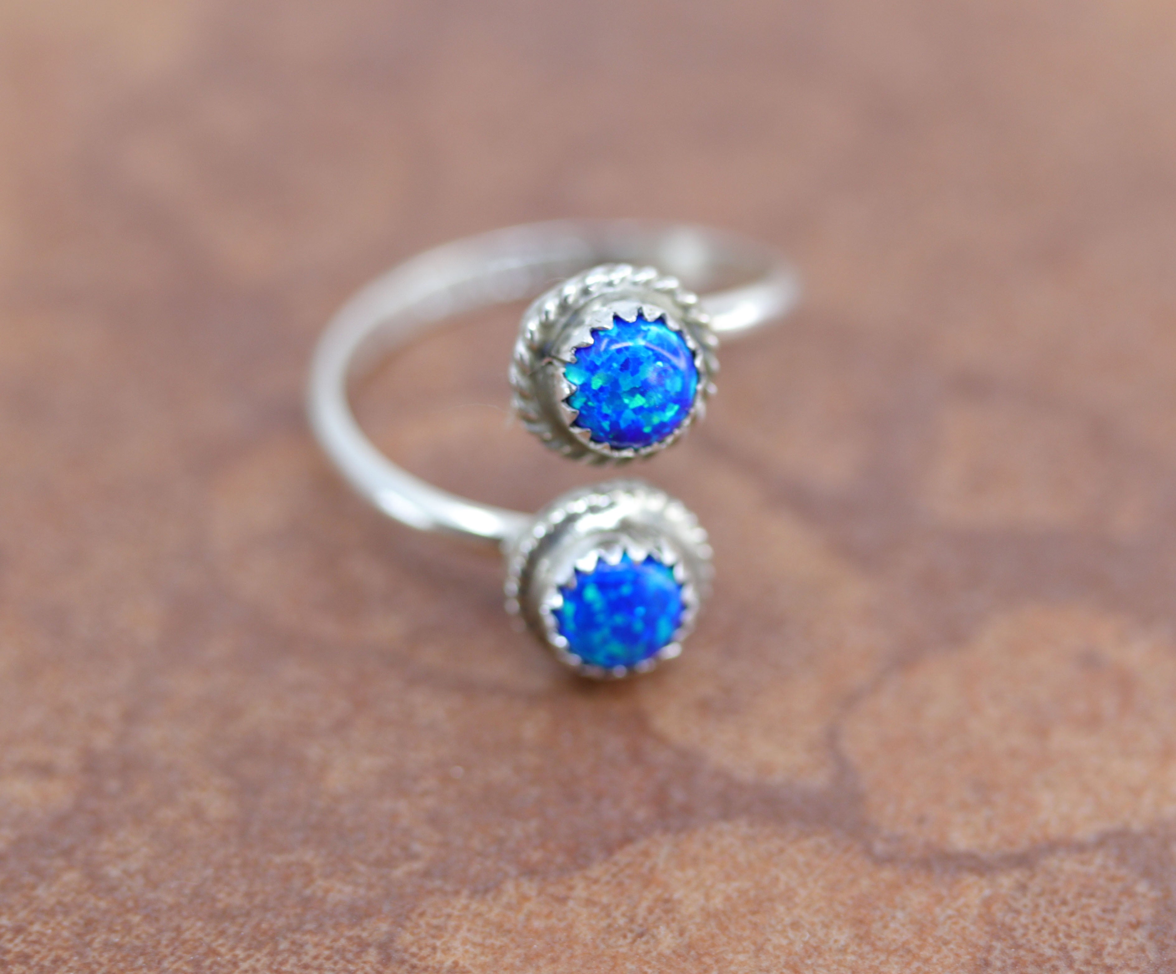 A beautiful Navajo Native American ring by Esther White. It is made from sterling silver and created opal. The size is adjustable so it can fit sizes 6-9, and it is 3/4" at the widest point.