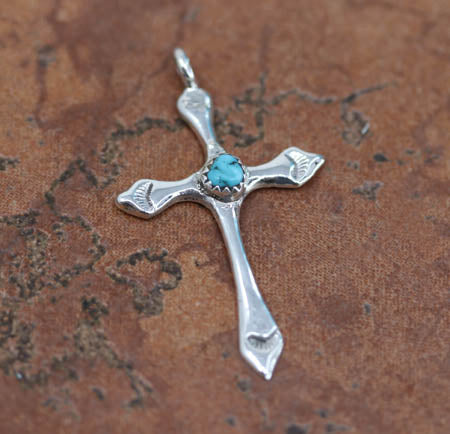 An authentic Navajo Native American Cross Pendant. It is made from Sterling Silver. It is about 2" in length including the bail, and about 1 1/8" in width.

