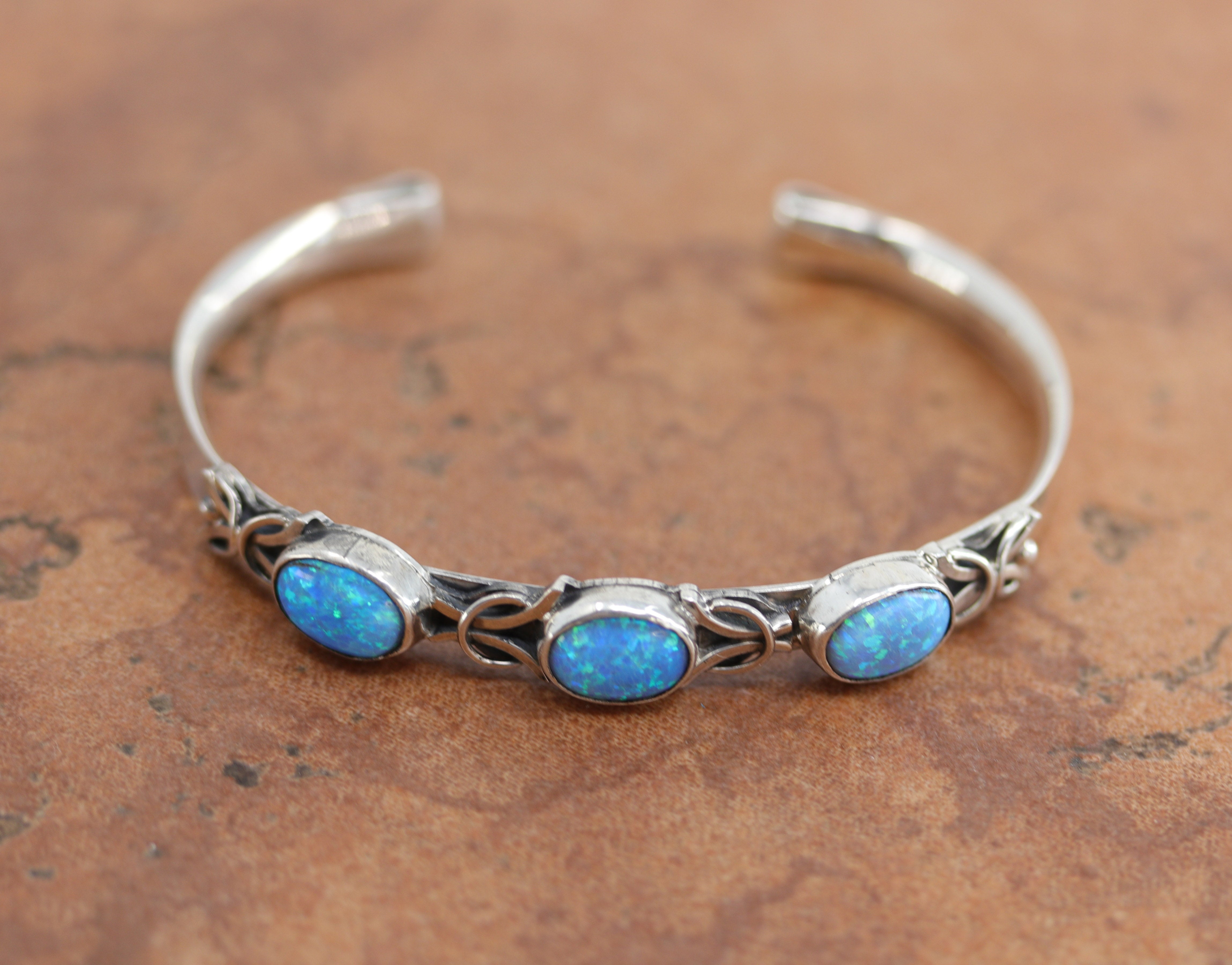 Navajo Native American bracelet by Thomas Yazzie. It is made from sterling silver and created opal. It is about 5 1/4" around and 3/8" wide. The opening is about 1", and it is partly flexible. 