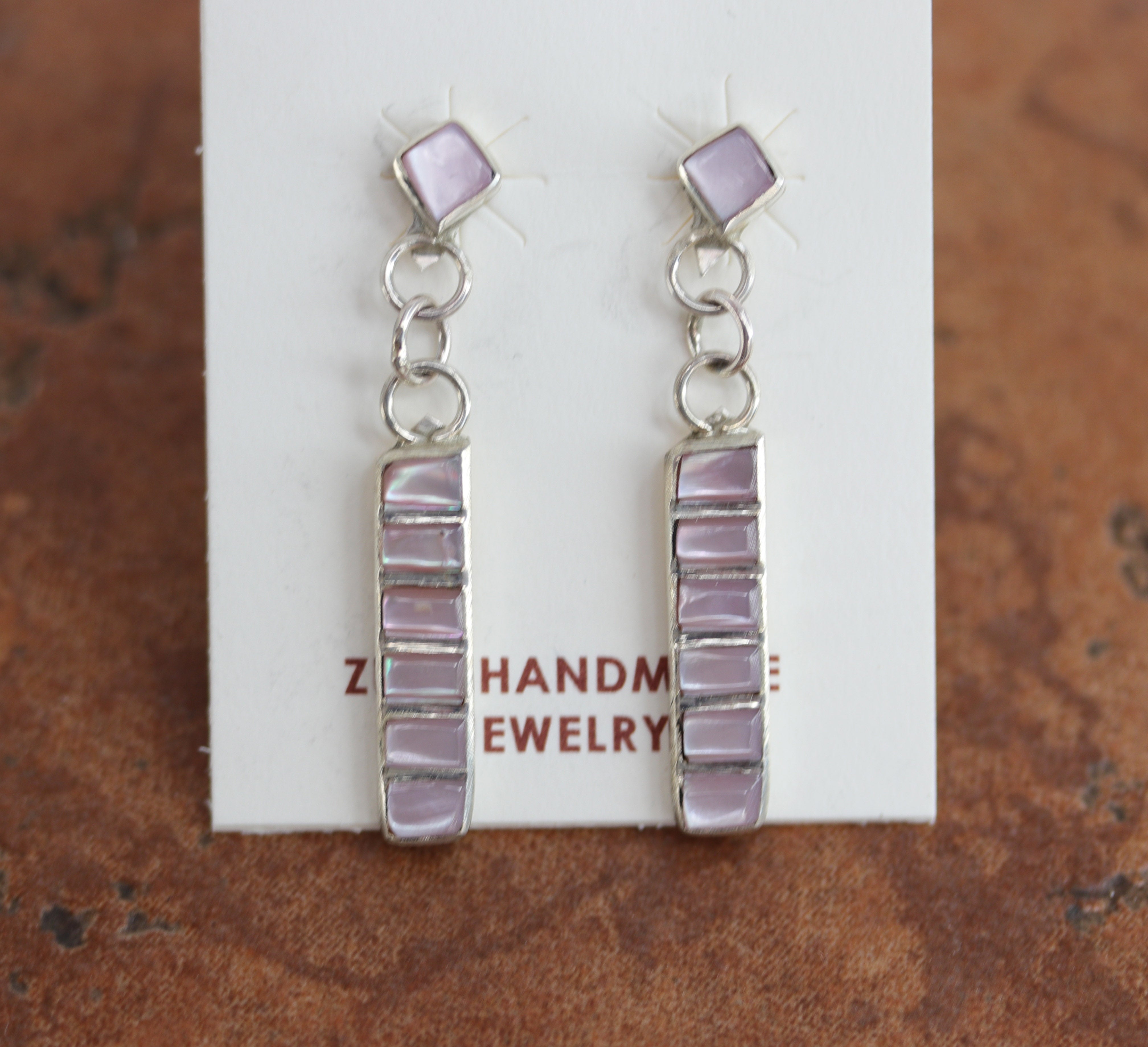 Brand new, very nice, Zuni Native American earrings. They are made from sterling silver and mother of pearl. The earrings are about 1 5/8" in length and 1/4" in width.