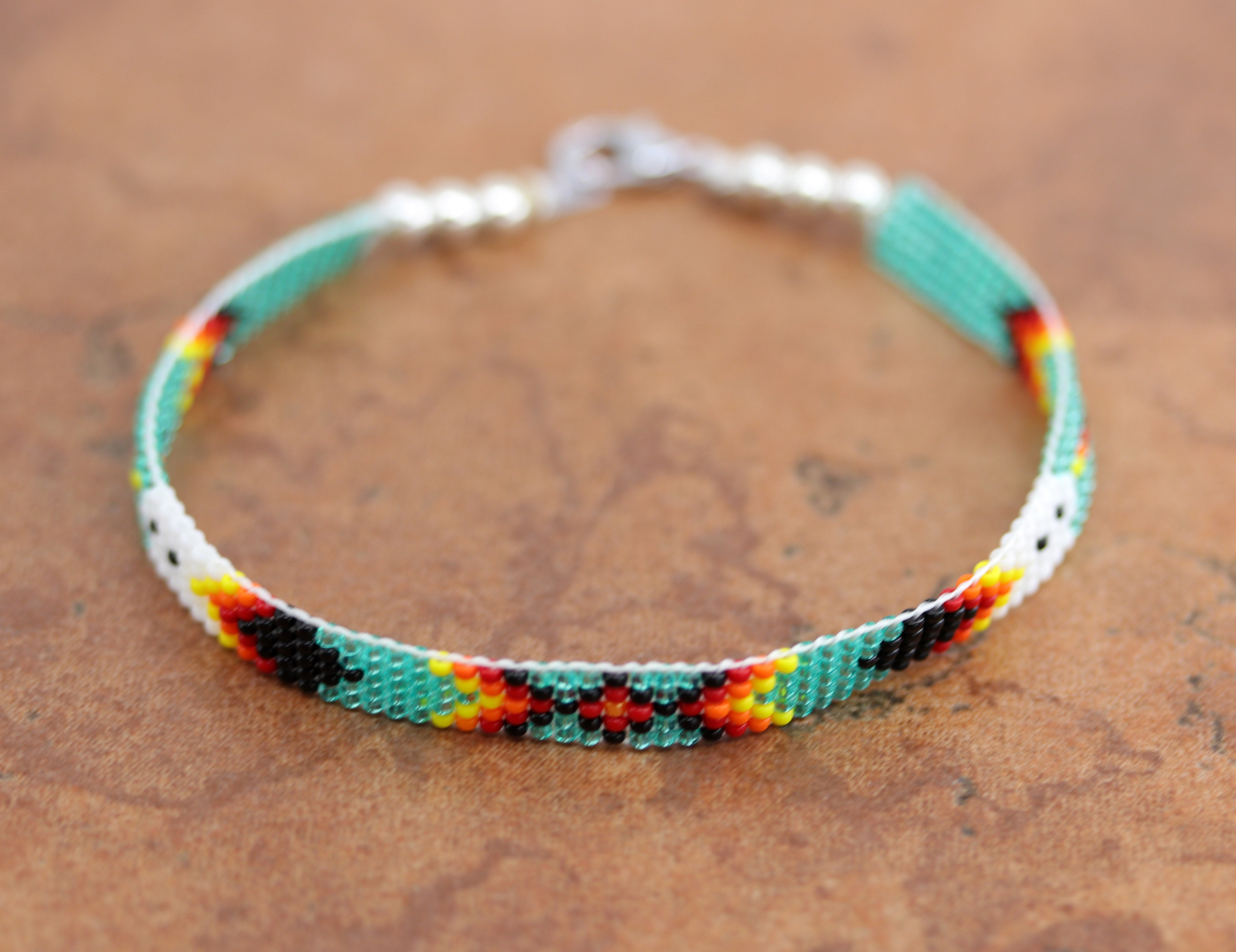 A beautiful Navajo green and white beaded bracelet. It is about 7 7/8" from end to end and the width is 1/4" at the widest point.