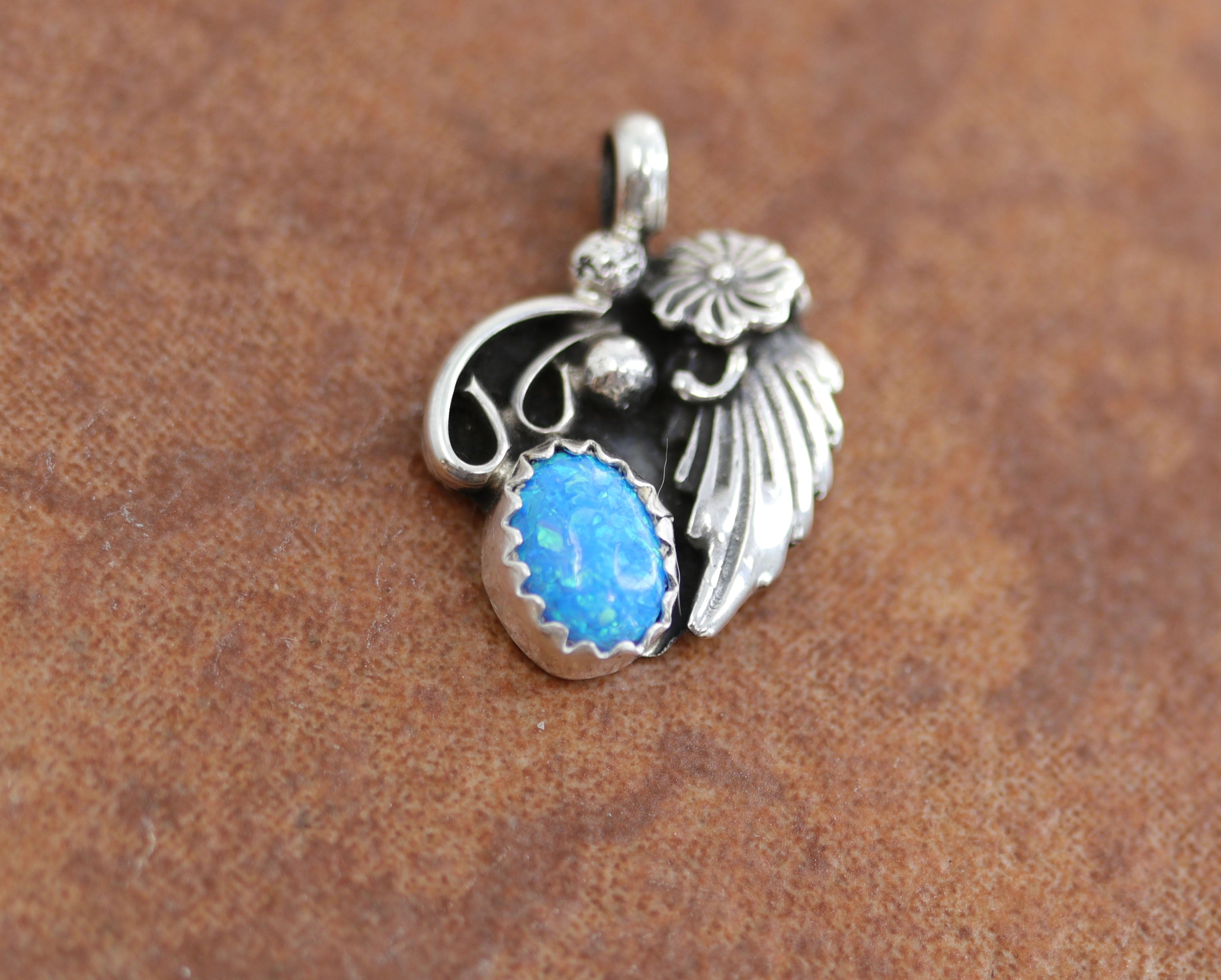 Navajo Native American Pendant. It is made from sterling silver and created opal. It is 3/4" long, and about 5/8" wide.