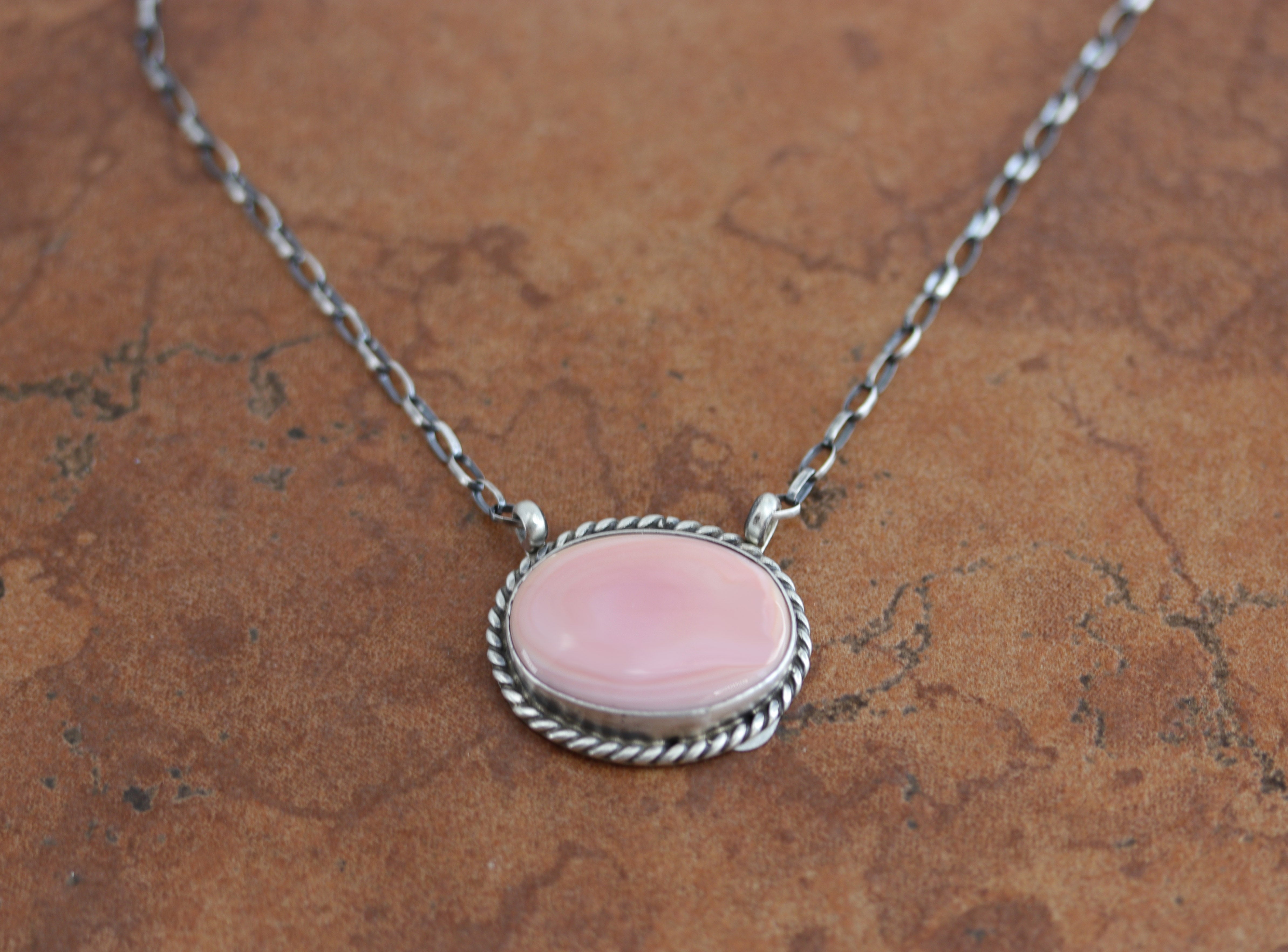 A beautiful necklace made by Eugene Balone. It is made from sterling silver and pink quartz. The necklace is about 17" in length. The center measures 1 1/8" in width.&nbsp;