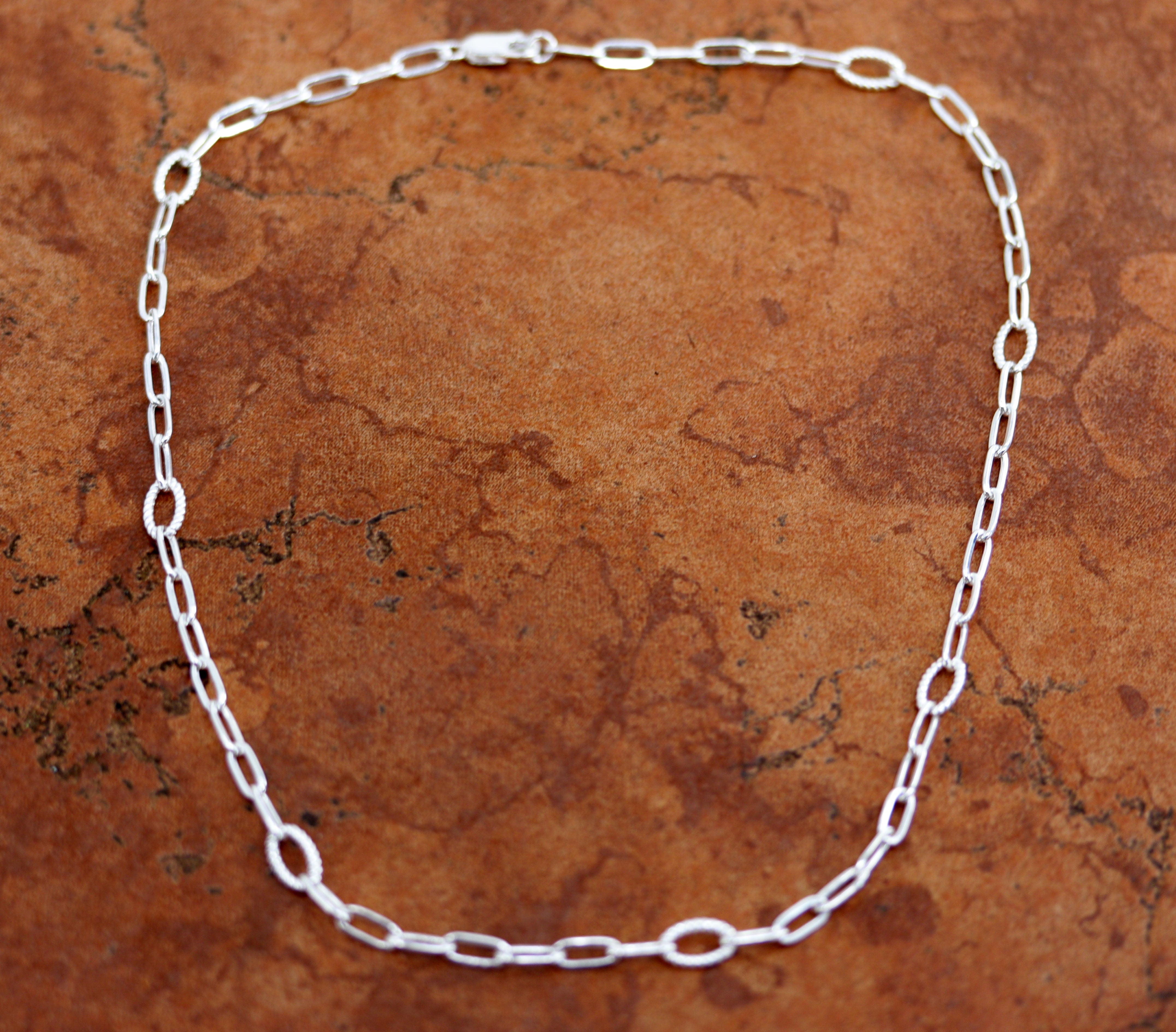 A Beautiful Paper Clip Chain Link Necklace. It is made from .925 sterling silver. The length is about 18" and the width is 3/16". 