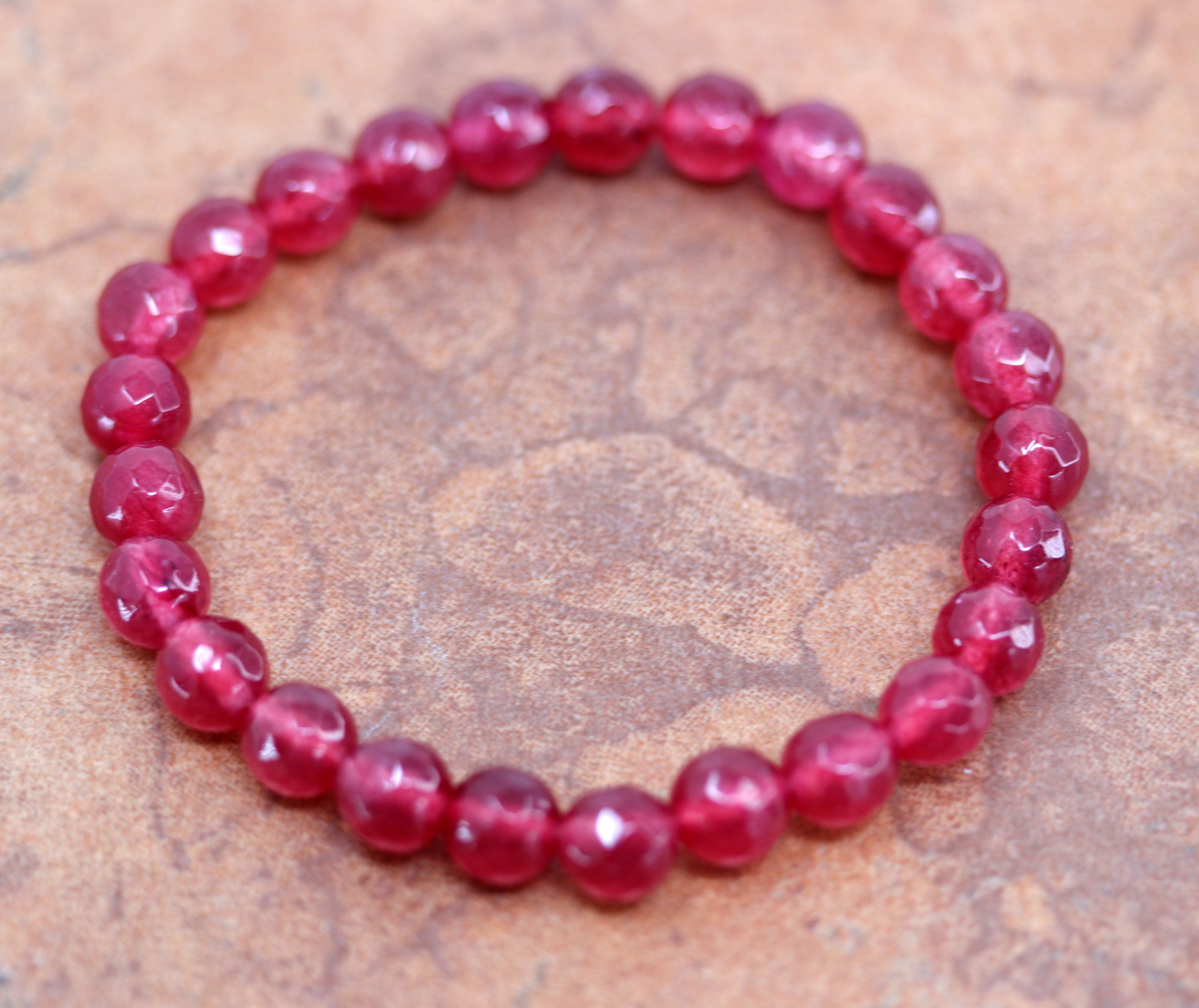 It fits sizes 6" (more loose) to about 9" (tighter fit). The width of the bracelet is 8 mm. It is made from red jade. 