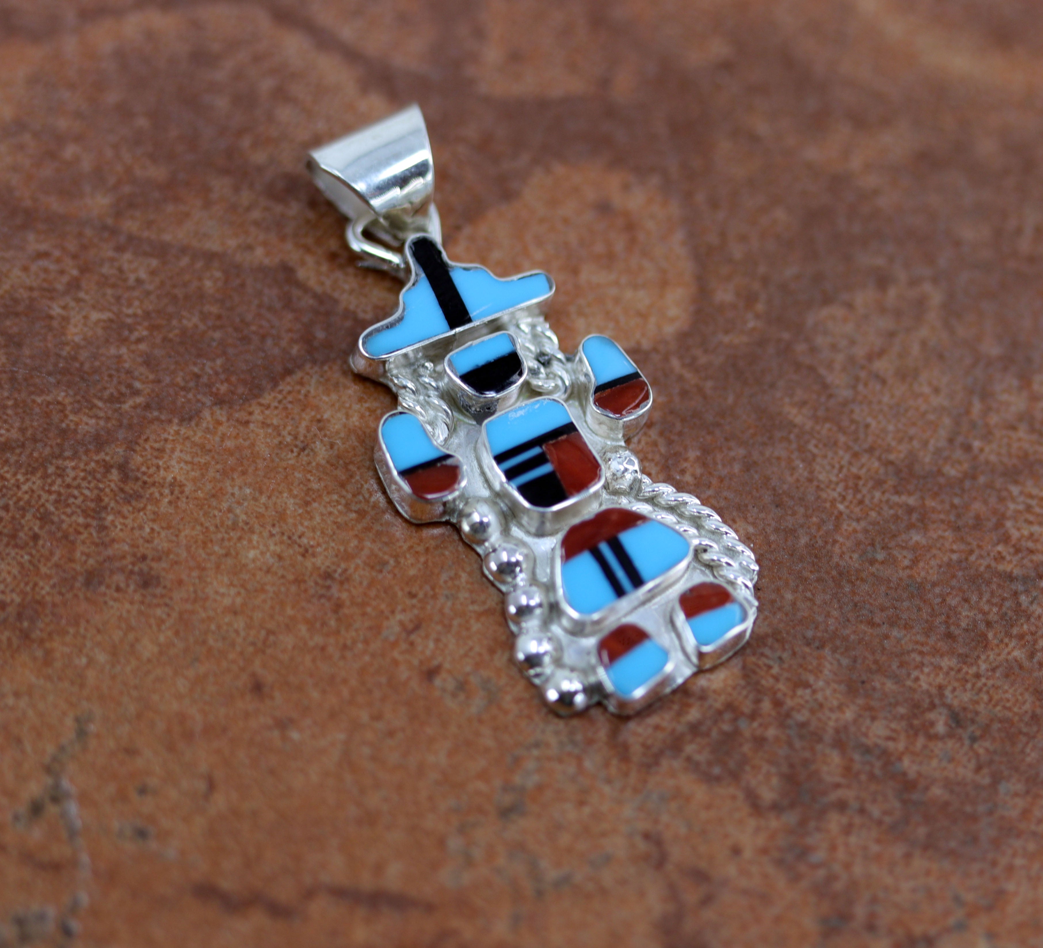 Zuni Native American Pendant. It is made from sterling silver and multi-stone inlay. It is 5/8" in width and 1 1/2" in length including the bail.